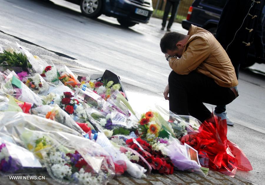 Flowers are laid at the entrance to the Royal Artillery Barracks in Woolwich in southeast London, May 23, 2013. A serving soldier was hacked to death by two attackers wielding knives including a meat cleaver near the Royal Artillery Barracks in Woolwich on Wednesday afternoon. (Xinhua/Bimal Gautam) 