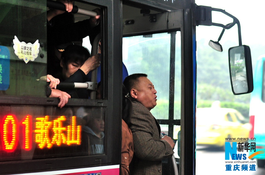 A man finally squeezes into the bus at the very moment when the door is closed in the morning in Chongqing. (Xinhua/Li Xiangbo) 