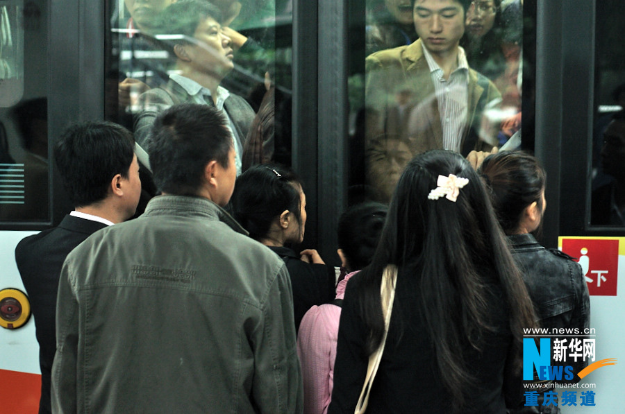 People rushes to the door and wait to get on the bus. (Xinhua/Li Xiangbo)
