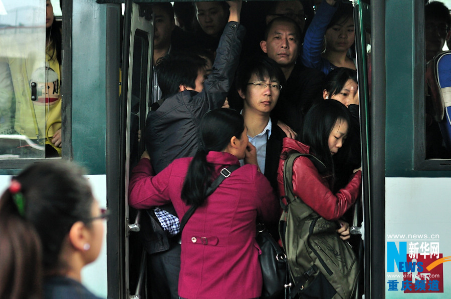 A woman squeezes into a crowded bus. (Xinhua/Li Xiangbo)