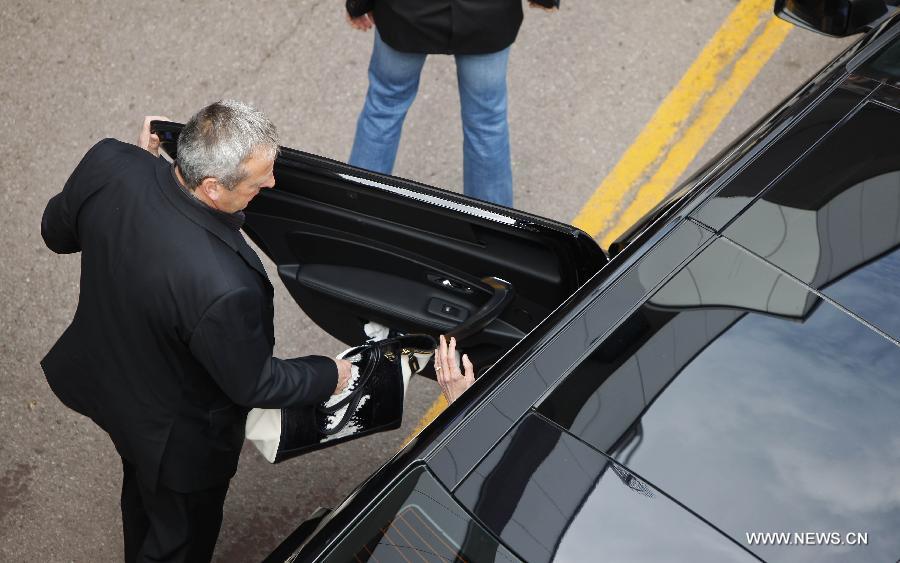  An entourage member passes the bag to Australian actress Nicole Kidman, a jury member for movies in Competition, as she leaves by car during the 66th Cannes Film Festival in Cannes, France, on May 15, 2013. The film festival runs from May 15 to May 26 this year.(Xinhua/Zhou Lei) 