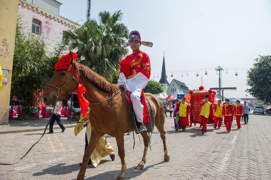 Bridegroom Zhang Lan rides to receive his Russian bride Ren Niya (her Chinese name) during the wedding ceremony in Chongqing, southwest China, May 23, 2013. The wedding ceremony, held in the traditional Chinese way, attracted lots of passengers to give their blessings. (Xinhua/Chen Cheng) 