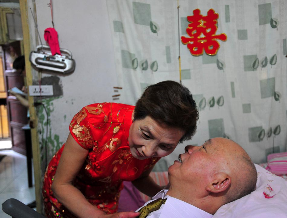 Tang Shaodou and Wang Mingfang before their long-delayed wedding ceremony in Wuhan, Central China's Hubei province, on May 21, 2013. Wang wears a red qipao for Tang, who was involved in an accident 35 years ago while preparing for their wedding. The accident left him paralyzed from the neck down. Wang stuck with him through the years and kept her wedding vow, saying, "Whether poverty or disease, we have to be together." (Photo/ Xinhua)