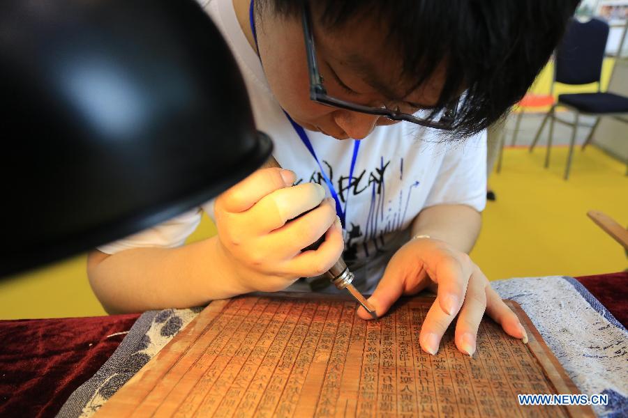 A working staff engraves sutra at the China (Nanjing) International Buddhist Cultural Items & Crafts Fair in Nanjing, capital of east China's Jiangsu Province, May 23, 2013. (Xinhua/Han Hua)