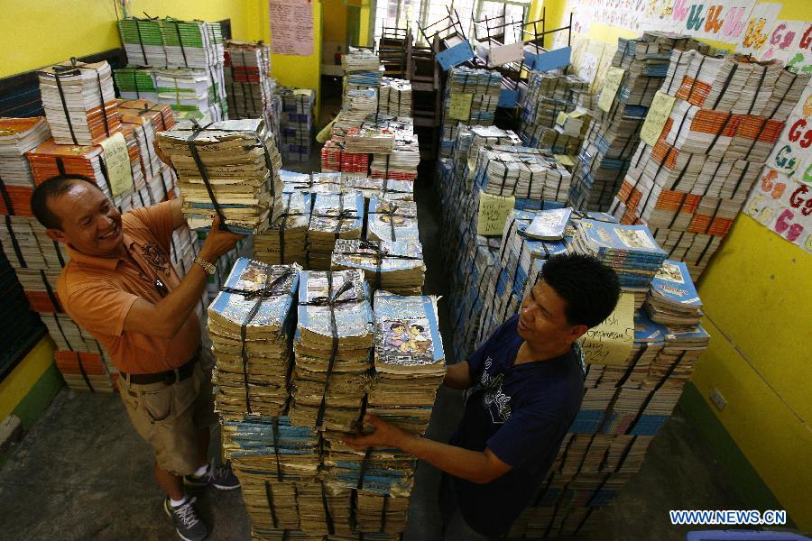 Teachers stack books to be distributed for the coming school year students in Bagong Silangan Elementary School in Quezon city, Philippines, May 24, 2013. The Department of Education (DepEd) of the Philippines is expecting around 23.8 million students to go into public and private elementary and high schools nationwide for the school year 2013-2014 that starts on June 3. (Xinhua/Rouelle Umali) 