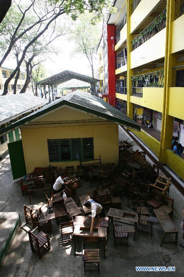 Janitors carry broken school chairs to be repaired for the coming school year in Bagong Silangan Elementary School in Quezon city, Philippines, May 24, 2013. The Department of Education (DepEd) of the Philippines is expecting around 23.8 million students to go into public and private elementary and high schools nationwide for the school year 2013-2014 that starts on June 3. (Xinhua/Rouelle Umali) 
