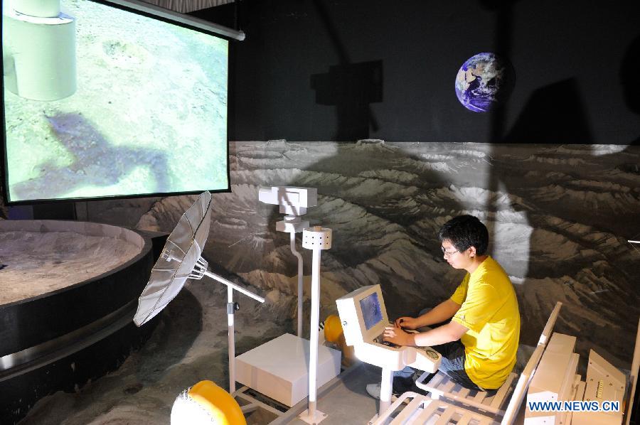 A visitor tries a simulation device to "explore" the moon during a scientific exhibition on lunar exploration in Guiyang, capital of southwest China's Guizhou Province, May 24, 2013. The exhibition, kicked off here Friday, showcased over 50 items. (Xinhua/Ou Dongqu)