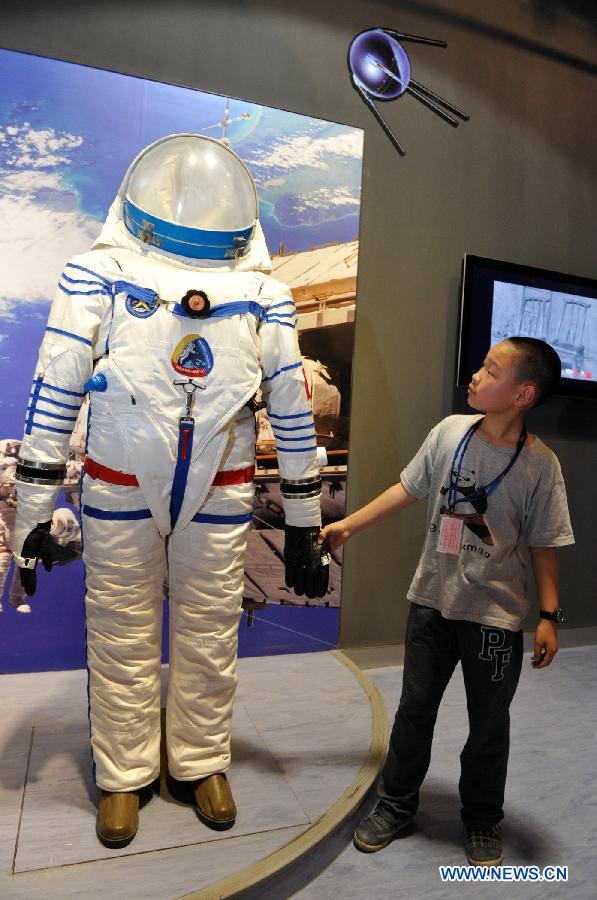 A boy views a space suit during a scientific exhibition on lunar exploration in Guiyang, capital of southwest China's Guizhou Province, May 24, 2013. The exhibition, kicked off here Friday, showcased over 50 items. (Xinhua/Ou Dongqu)