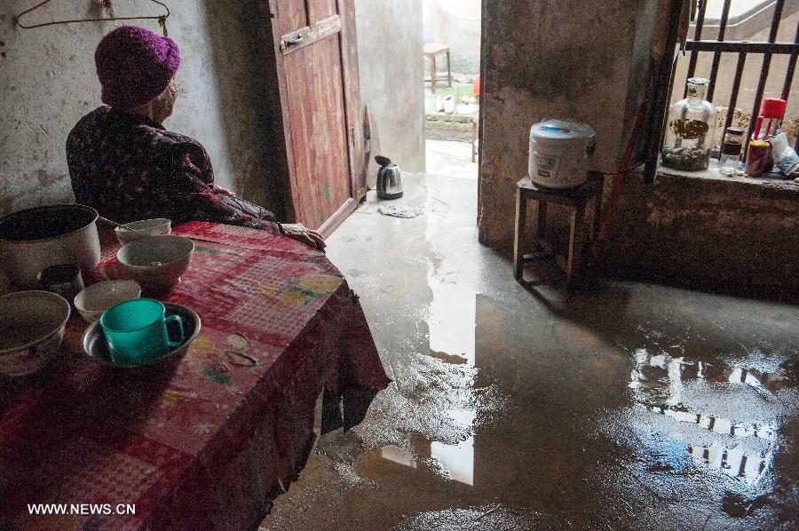 A woman aged over 90 sits in her flooded house in Daba Village of Jiaoling County, Meizhou City, South China's Guangdong Province, May 22, 2013. Living apart from their son, the senior couple have to rely on themselves after the rainstorm hitting Guangdong Province on May 18. With the youth attending school or working outside their hometowns, the left-behind family members are becoming even more vulnerable after natural disasters. (Xinhua/Mao Siqian) 