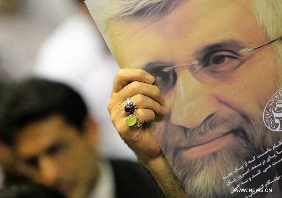 A man holds up a poster of Iran's chief nuclear negotiator and presidential candidate Saeed Jalili during a campaign rally in downtown Tehran, Iran, on May 24, 2013. Iran's Guardian Council of Constitution announced the names of eight eligible candidates for the upcoming presidential election while barring two major political figures from running for presidency. (Xinhua/Ahmad Halabisaz) 