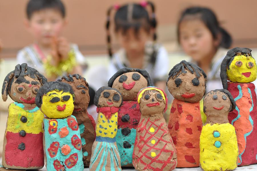 Children make figurines with mud at a kindergarten in Yuezhuang Town of Yiyuan County, east China's Shandong Province, May 24, 2013. Children here use waste materials to make toys to celebrate the coming Children's Day in a low-carbon way. (Xinhua/Zhao Dongshan)