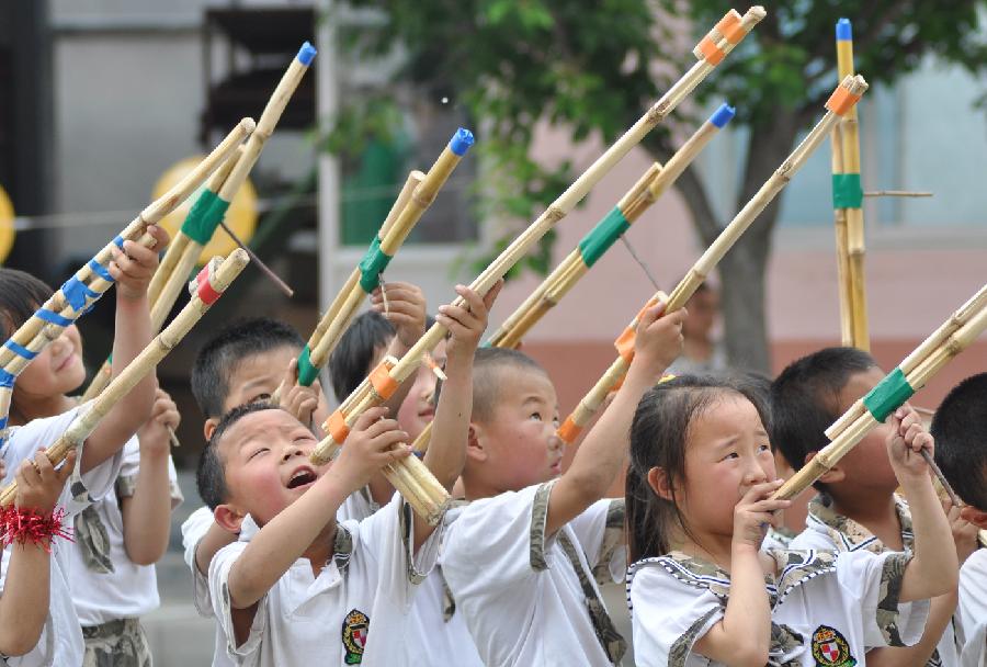 Children play with toy guns made of corn stalks at a kindergarten in Yuezhuang Town of Yiyuan County, east China's Shandong Province, May 24, 2013. Children here use waste materials to make toys to celebrate the coming Children's Day in a low-carbon way. (Xinhua/Zhao Dongshan)