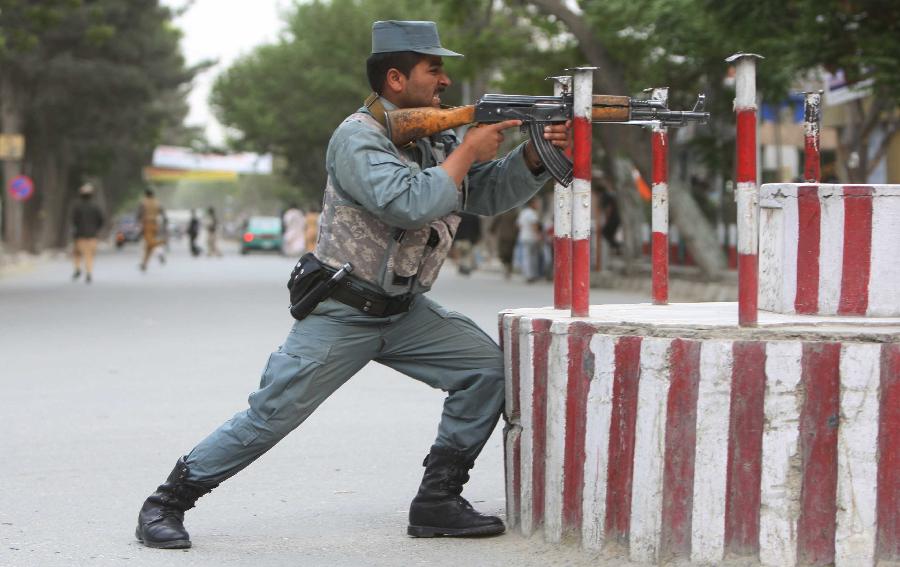 An Afghan policeman aims at the site of an attack in Kabul, Afghanistan on May 24, 2013. At least two suicide bombers and a policeman were killed and several others wounded on Friday evening when Taliban launched a coordinated attack in central Kabul, a police source said. (Xinhua/Ahmad Massoud) 