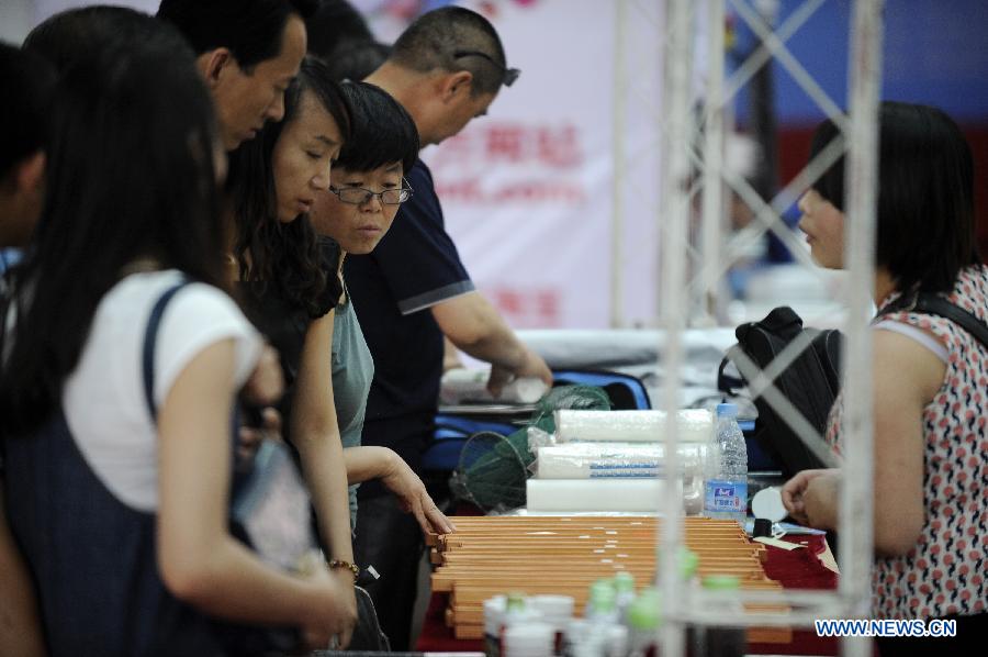 People select fishing gear at the 3rd Yinchuan fishing gear expo in Yinchuan, capital of northwest China's Ningxia Hui Autonomous Region, May 25, 2013. (Xinhua/Li Ran)