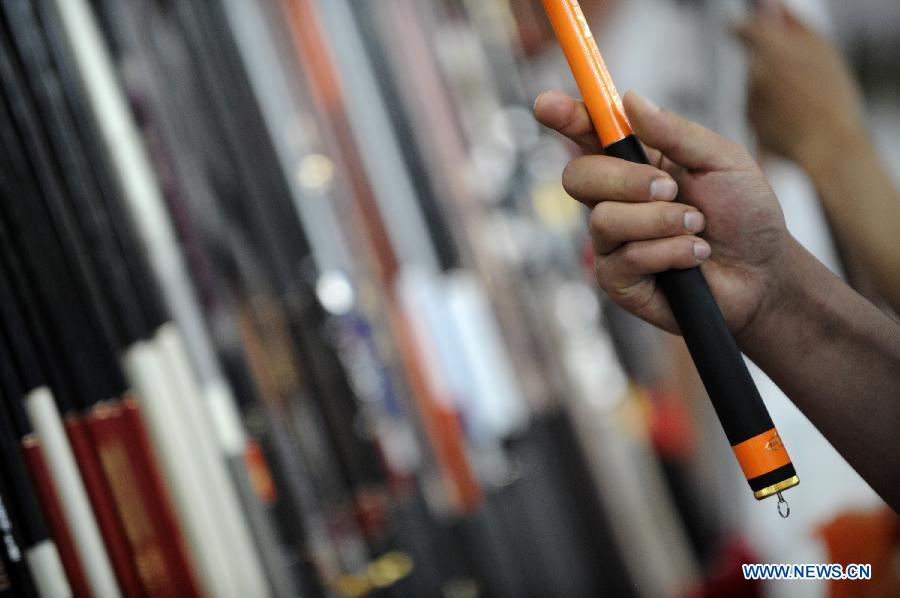 Fishing fans select fishing rods at the 3rd Yinchuan fishing gear expo in Yinchuan, capital of northwest China's Ningxia Hui Autonomous Region, May 25, 2013. (Xinhua/Li Ran)