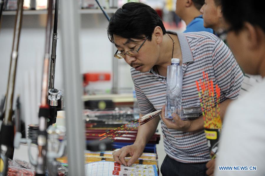 Fishing fans select baits at the 3rd Yinchuan fishing gear expo in Yinchuan, capital of northwest China's Ningxia Hui Autonomous Region, May 25, 2013. (Xinhua/Li Ran)