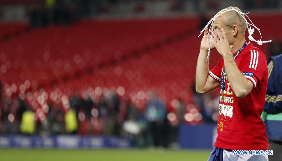 Arjen Robben of Bayern Munich celebrates with a piece of the goal net after the awarding ceremony for the UEFA Champions League final football match between Borussia Dortmund and Bayern Munich at Wembley Stadium in London, Britain on May 25, 2013. Bayern Munich claimed the title with 2-1.(Xinhua/Wang Lili)