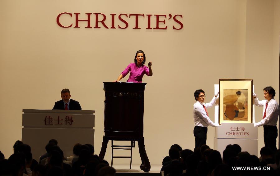 An auctioneer auctions a painting work at an auction of the Asian 20th Century & Contemporary Art held by Christie's in Hong Kong, south China, May 25, 2013. The five-day Christie's 2013 spring auctions kicked off in Hong Kong on May 25. (Xinhua/Li Peng)