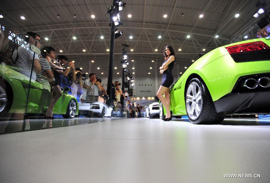 A model presents a car at an auto show in Wuhan, capital of central China's Hubei Province, May 26, 2013. The four-day auto show, which kicked off on Saturday, attracted more than 70 auto brands. (Xinhua/Xiao Yijiu) 