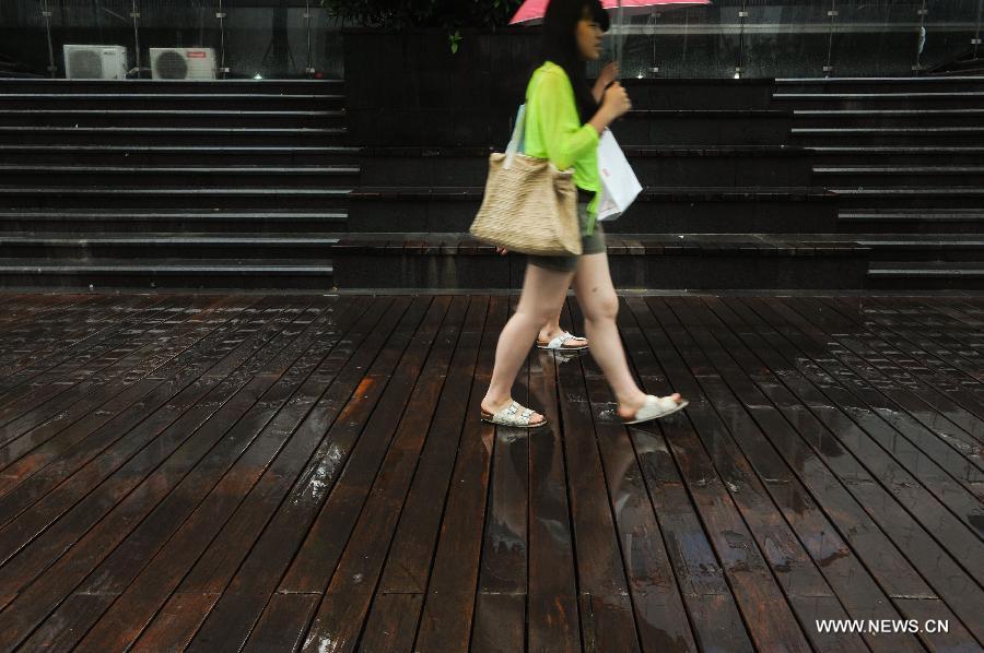 Pedestrians walk amid rain in Shenzhen, south China's Guangdong Province, May 26, 2013. Torrential rain hit most parts of Guangdong Province from Saturday to Sunday. (Xinhua/Mao Siqian)