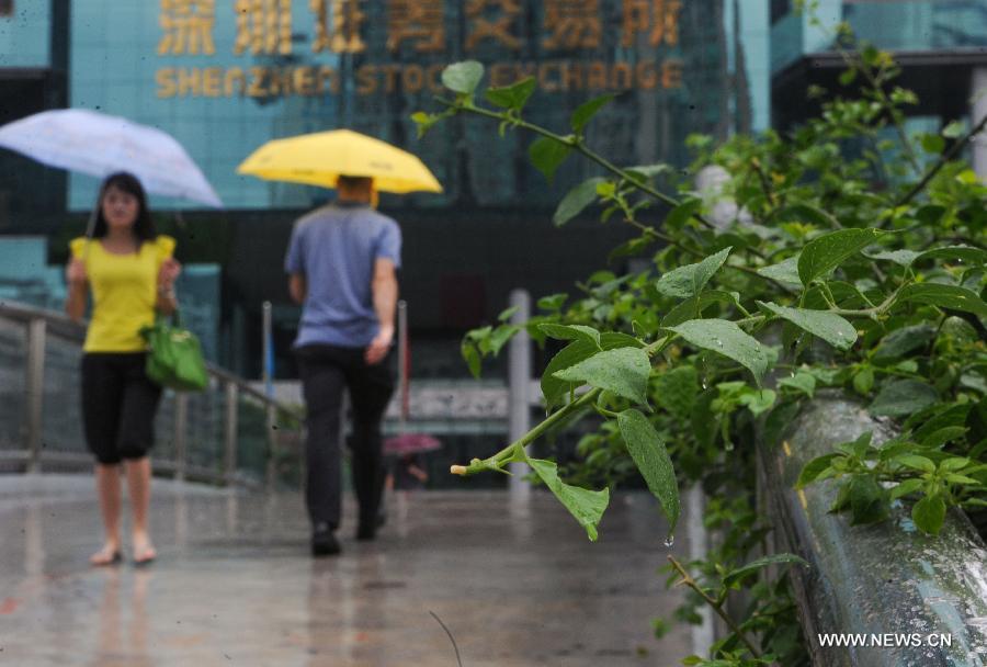 Pedestrians walk amid rain in Shenzhen, south China's Guangdong Province, May 26, 2013. Torrential rain hit most parts of Guangdong Province from Saturday to Sunday. (Xinhua/Mao Siqian)