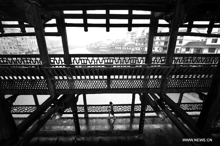 A pedestrian walks on a veranda bridge in Xuan'en County, central China's Hubei Province, May 25, 2013. Veranda bridge is a typical architecture of China's Dong ethnic group in south China. (Xinhua/Song Wen)  