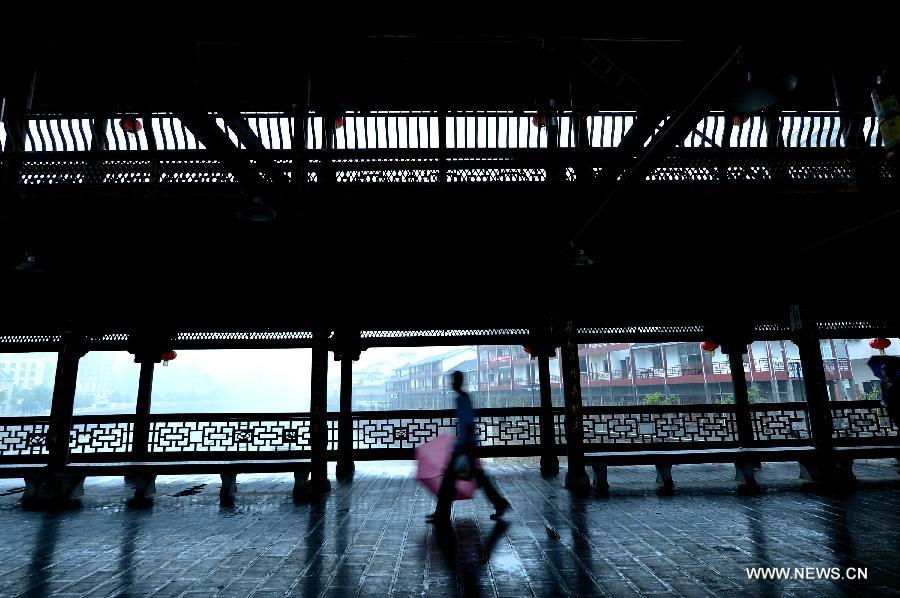 A man walks on a veranda bridge in Xuan'en County, central China's Hubei Province, May 25, 2013. Veranda bridge is a typical architecture of China's Dong ethnic group in south China. (Xinhua/Song Wen)  