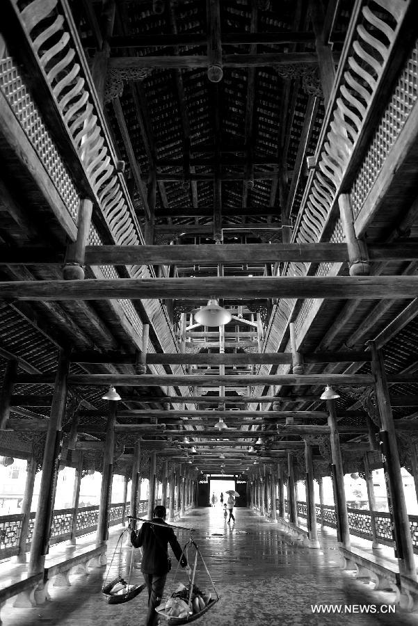 Pedestrians walk on a veranda bridge in Xuan'en County, central China's Hubei Province, May 25, 2013. Veranda bridge is a typical architecture of China's Dong ethnic group in south China. (Xinhua/Song Wen)  