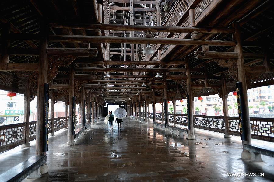 Pedestrians walk on a veranda bridge in Xuan'en County, central China's Hubei Province, May 25, 2013. Veranda bridge is a typical architecture of China's Dong ethnic group in south China. (Xinhua/Song Wen)  