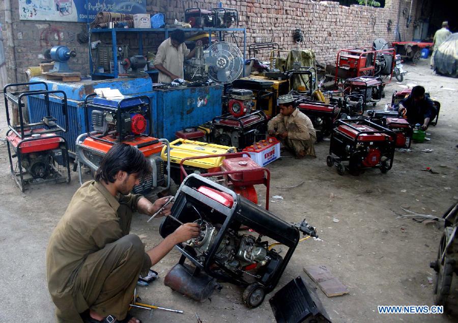 Workers repair electric generators at a workshop in Peshawar, northwest Pakistan, May 26, 2013. Power shortfall across the country has reached over 5,500 megawatts. (Xinhua/Ahmad Sidique) 