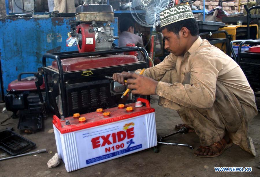 A worker repairs an electric generator at a workshop in Peshawar, northwest Pakistan, May 26, 2013. Power shortfall across the country has reached over 5,500 megawatts. (Xinhua/Ahmad Sidique) 