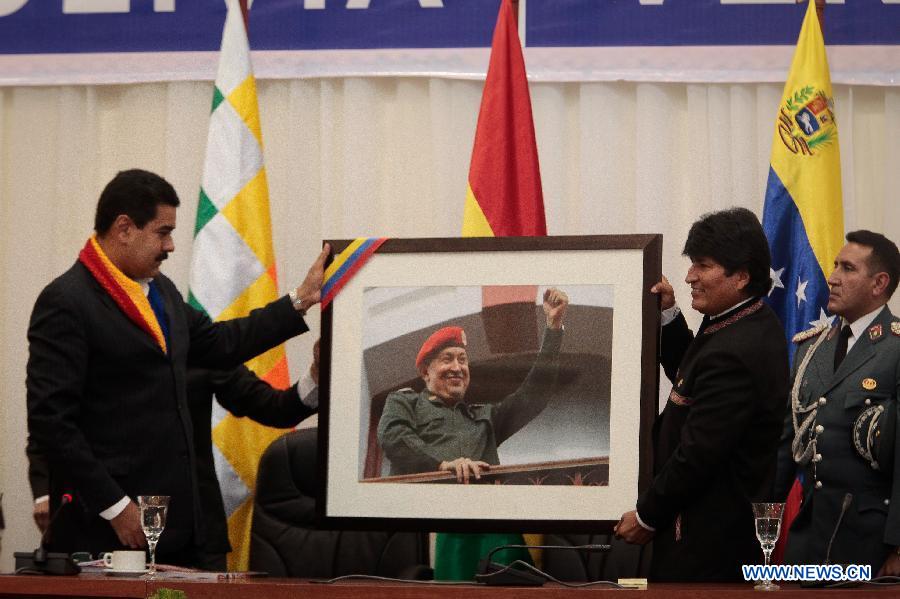 Photo provided by Venezuela's Presidency shows Bolivian President Evo Morales (2nd R) and Venezuelan President Nicolas Maduro displaying a portrait of late former Venezuelan President Hugo Chavez during the second meeting of the Bolivia-Venezuela Joint Integration Commission, in Cochabamba City, Bolivia, on May 25, 2013. (Xinhua/Venezuelas Presidency) 