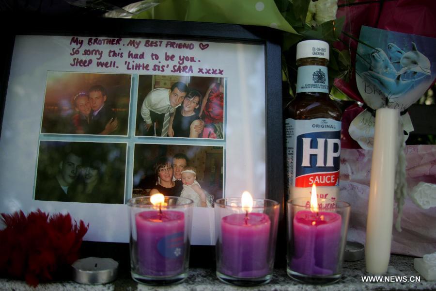 Pictures and candles are placed at the site where British soldier Lee Rigby was murdered in Woolwich, east London on May 26, 2013. (Xinhua/Bimal Gautam) 
