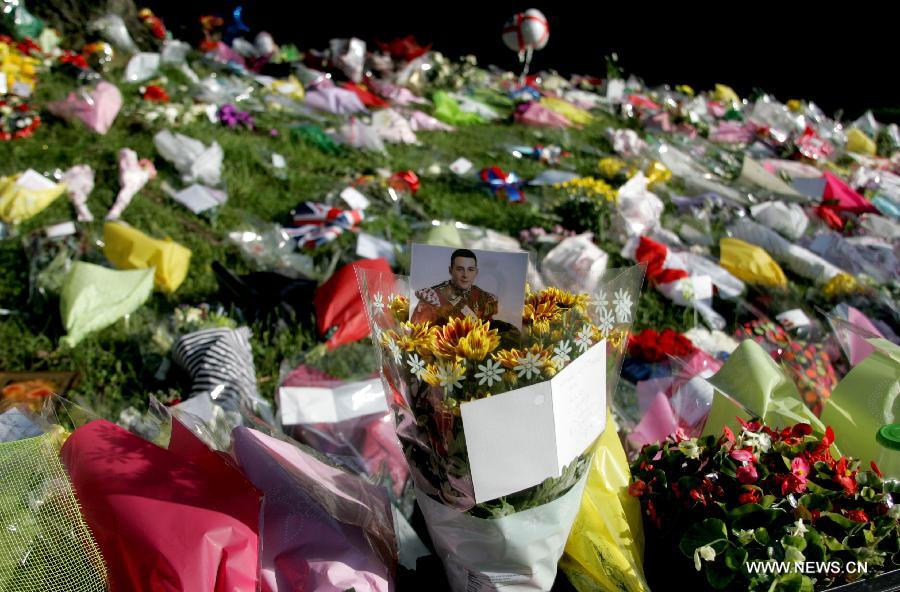 Flowers and cards are placed at the site where British soldier Lee Rigby was murdered in Woolwich, east London on May 26, 2013. (Xinhua/Bimal Gautam) 