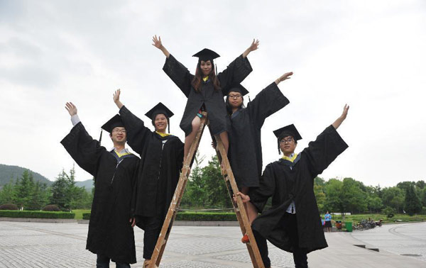 Graduates wearing academic dresses pose for a group photo at Zhejiang Agriculture and Farming University in Hangzhou, capital of East China's Zhejiang province, May 26, 2013. [Photo/Xinhua]