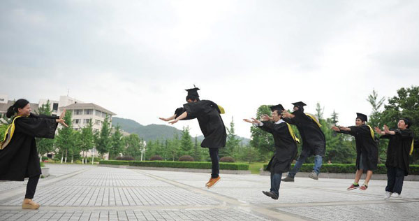 Graduates wearing academic dresses pose for a group photo at Zhejiang Agriculture and Farming University in Hangzhou, capital of East China's Zhejiang province, May 26, 2013. [Photo/Xinhua]