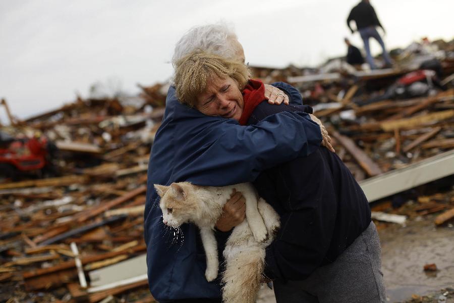 June Simson (R) receives a hug from her neighbor Jo McGee while embracing her cat Sammi after she found him standing on the rubble of her destroyed home on May 21, 2013 in Moore, Oklahoma. (Xinhua/AFP Photo)