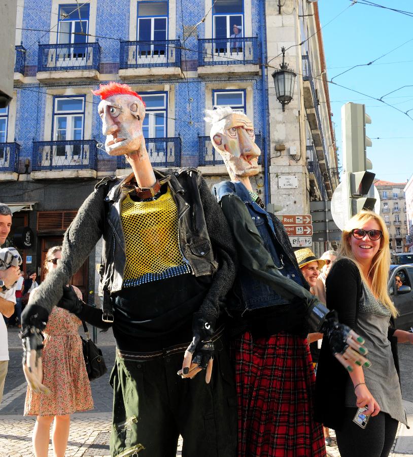 Two giant "puppets" perform on a street in Lisbon, capital of Portugal, May 23, 2013. The International Festival of Puppetry and Animated Forms was held in Lisbon from May 17 to June 9, with the participation of around 20 troupes from all over the world. (Xinhua/Zhang Liyun)