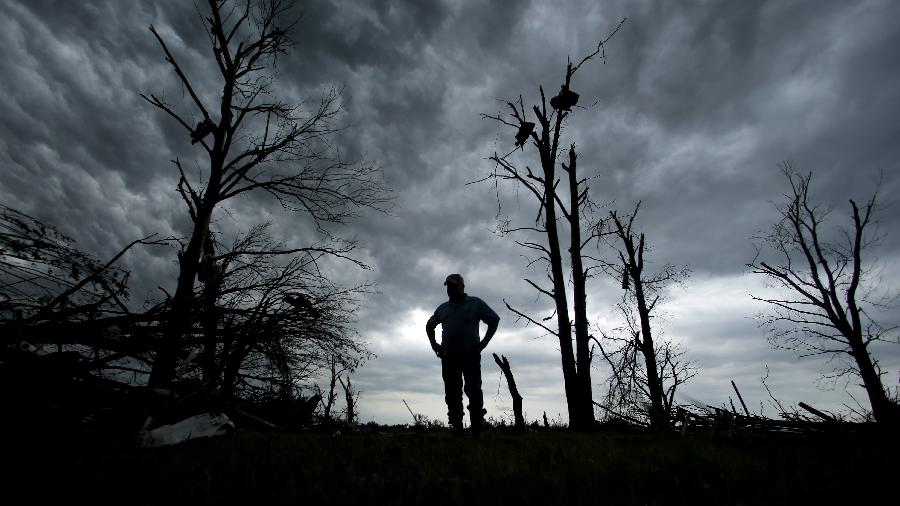 A man stands over a destroyed home as the sun rises on May 23, 2013 in Moore, Oklahoma. (Xinhua/AP Photo)