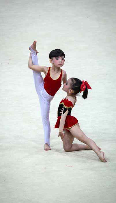 A boy and a girl perform basic gymnastics in the National Children's Gymnastic Assembly in Jiangsu province on May 23, 2013. (Xinhua Photo/ Huangzhe)