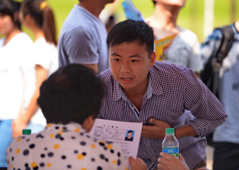 A job-seeking college student introduces himself to a company in a job fair in Nanchang, Jiangxi province on May 23, 2013, less than a month before college students’ graduation. (Xinhua Photo/ Zhou Mi)