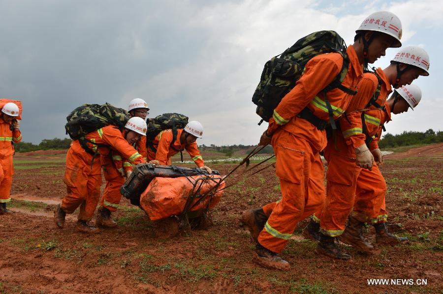 Firefighters participate in a rescue drill in Malong County of Qujing City, southwest China's Yunnan Province, May 25, 2013. A total of 116 firefighters attended the rescue drill for earthquake emergencies. (Xinhua/Hou Wenkun)