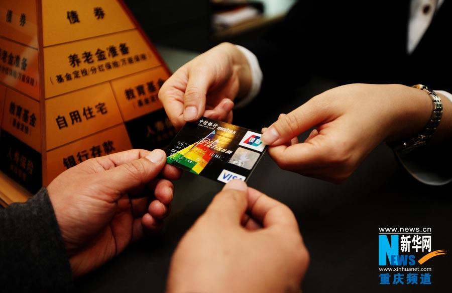 Lu Yanlin grants a credit card to client. (Photo/Xinhua)