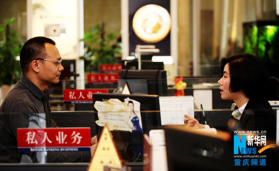 Lu Yanlin answers client's question about financial investment in the bank. (Photo/Xinhua)