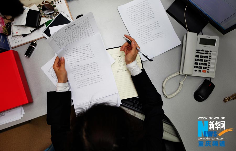 Chen Shan checks the collected materials and does financial assessment for an enterprise. (Photo/Xinhua)