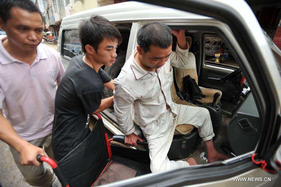 Lan Chuan (C) helps his father Lan Zhongguo walk down a car at Fozi Village in Shanglin County of Nanning City, capital of southwest China's Guangxi Zhuang Autonomous Region, May 26, 2013. Lan, a 15-year-old middle school student, lives with his paralyzed father on fixing farming machines. Without the care of mother who left the family when he was three years old, Lan takes care of his father and supports his family by aiding him with the fixing work. His story has moved many people in the region, which also brought him the title of "juvenile of virtues " of Nanjing in 2012. (Xinhua/Lu Boan)