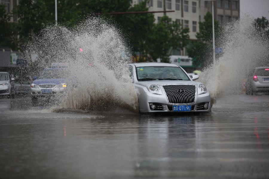 A car drives on a flooded road in Heze City, east China's Shandong Province, May 26, 2013. A heavy rainfall hit Shandong Province from May 25 to 26. (Xinhua/Zhou Donglun) 