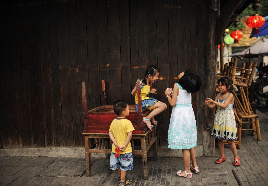 Children play in Anren, an ancient town in Dayi County of Chengdu, capital of southwest China's Sichuan Province, May 23, 2013. Anren Town was first built in ancient China's Tang Dynasty (618-907). Most of its buildings were constructed in late Qing Dynasty (1644-1911) and early Republic of China (1911-1949). Chengdu will host the Global Fortune Forum, an event to be organized by the American magazine "Fortune", on June 6-8. (Xinhua/Shen Hong) 