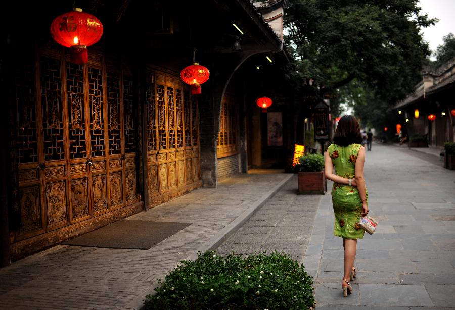A woman walks on a street in Anren, an ancient town in Dayi County of Chengdu, capital of southwest China's Sichuan Province, May 23, 2013. Anren Town was first built in ancient China's Tang Dynasty (618-907). Most of its buildings were constructed in late Qing Dynasty (1644-1911) and early Republic of China (1911-1949). Chengdu will host the Global Fortune Forum, an event to be organized by the American magazine "Fortune", on June 6-8. (Xinhua/Shen Hong)