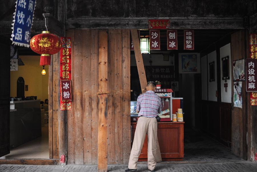 A resident closes his shop in Anren, an ancient town in Dayi County of Chengdu, capital of southwest China's Sichuan Province, May 23, 2013. Anren Town was first built in ancient China's Tang Dynasty (618-907). Most of its buildings were constructed in late Qing Dynasty (1644-1911) and early Republic of China (1911-1949). Chengdu will host the Global Fortune Forum, an event to be organized by the American magazine "Fortune", on June 6-8. (Xinhua/Shen Hong) 